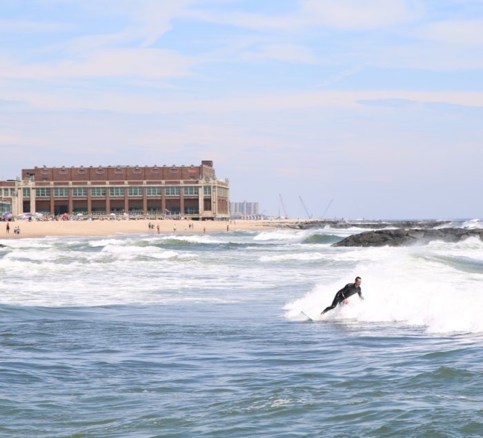 Surfer in the Ocean in front of Conventional Hall, Asbury Park South Beach